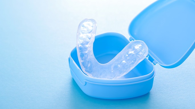 A nightguard sitting in a light blue protective case