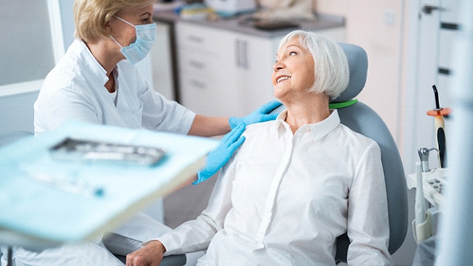 Senior dental patient learning about advanced dental implant procedures in Philadelphia