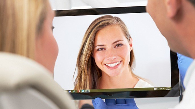 Dentist and patient looking at virtual smile design images
