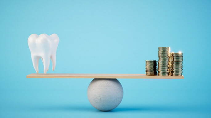 a 3D illustration of a large tooth and stacks of coins on a balance eam