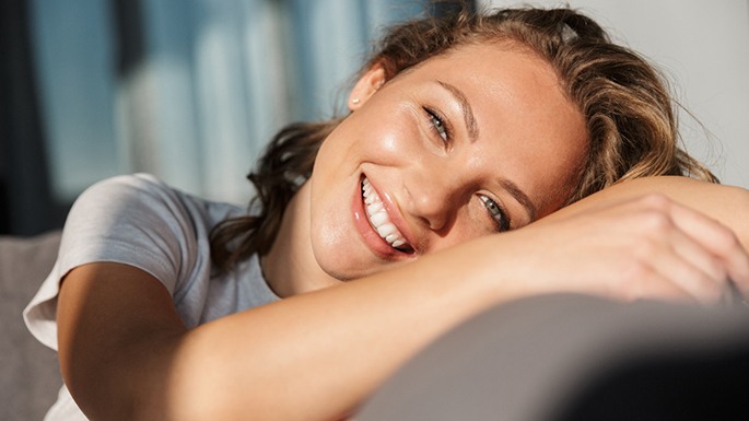 Young woman smiling and relaxing on couch
