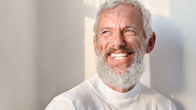 Senior man with a beard and white sweater