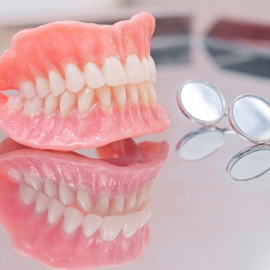 Close-up of dentures in Philadelphia, PA on reflective table