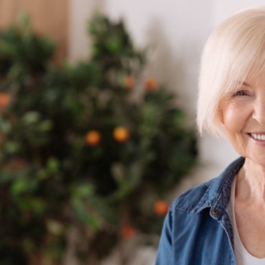 Senior woman smiling and wearing a denim jacket