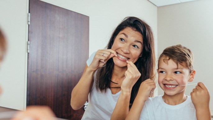 Mother and son flossing to prevent dental emergencies in Philadelphia