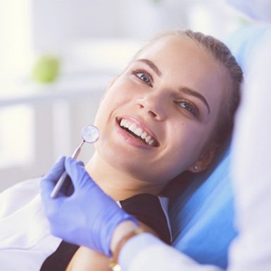 Smiling woman visiting an emergency dental office in Philadelphia
