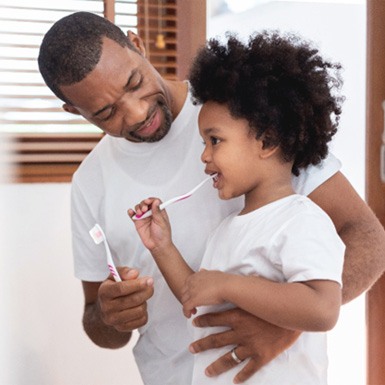 Father and son brushing teeth to prevent dental emergencies in Philadelphia