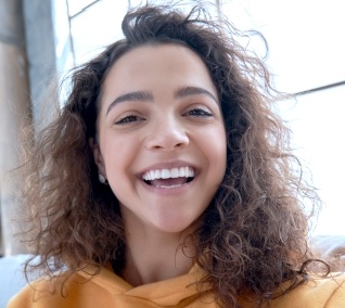 Young woman in orange hoodie smiling