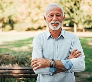 Man in light blue shirt smiling outdoors