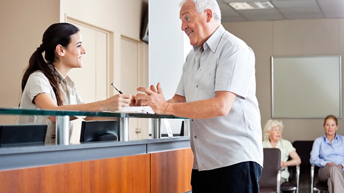 Patient talking with dental receptionist about payment options