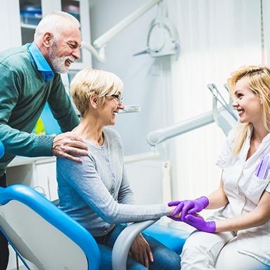 Older couple smiling with an implant dentist in Philadelphia