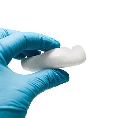 Implant dentist in Philadelphia holding a mouthguard
