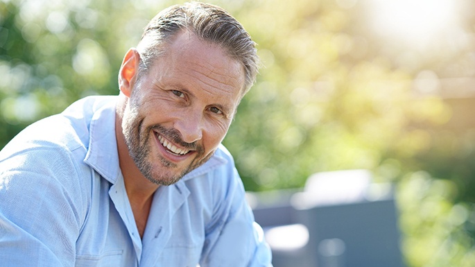 smiling man who understands the implant dentures procedure