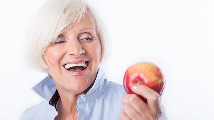 woman smiling and enjoy the benefits of implant dentures in Philadelphia