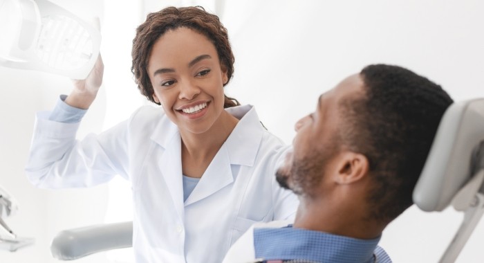 Dentist smiling at dental patient in treatment chair