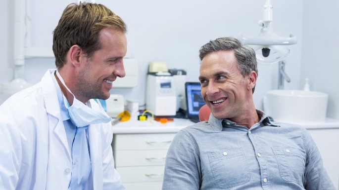 Dentist talking to patient in dental chair