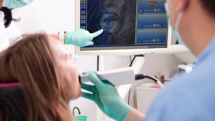 Dentist and patient looking at smile images on computer