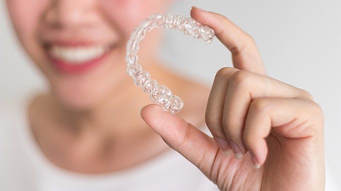 Patient holding an Invisalign clear aligner tray