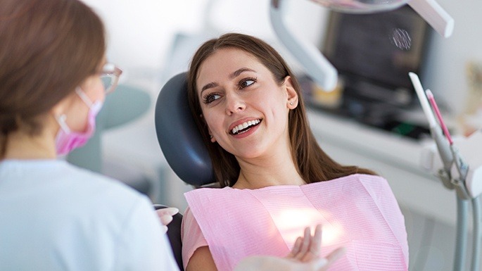 Woman smiling at dentist during preventive dentistry checkup and teeth cleaning visit