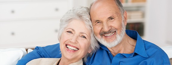 Man and woman smiling after periodontal therapy