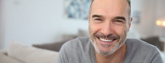 Man smiling after replacing missing teeth with dental implants