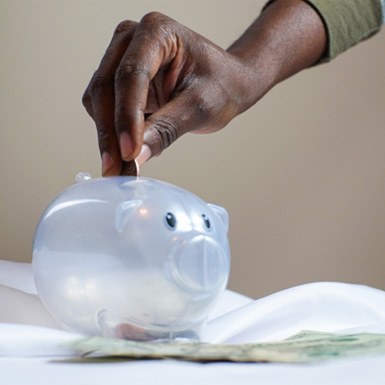 Hand putting coin in piggy bank