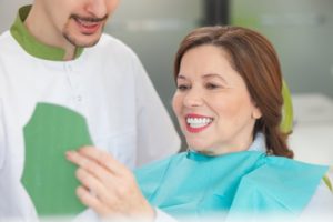 mature woman looking at teeth in mirror 