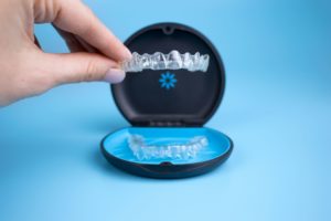 Someone lifting Invisalign out of storage case