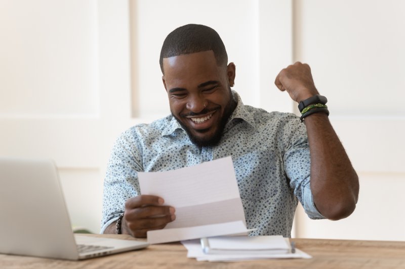 Older dentures patient smiling at finances